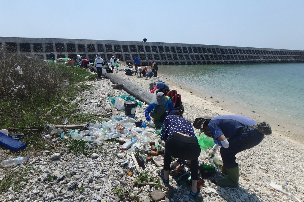 志工協助撿拾及分類沙灘上的垃圾 志工協助撿拾及分類沙灘上的垃圾