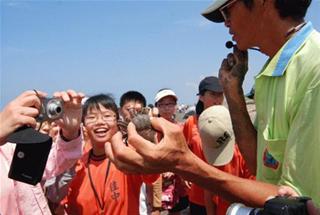 圖4:老師手中的招潮蟹是學生眼中最佳的生態教材。攝影:葉品妤 圖4:老師手中的招潮蟹是學生眼中最佳的生態教材。攝影:葉品妤